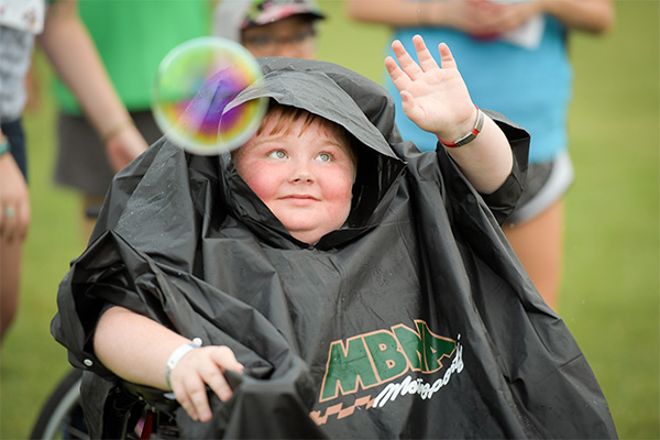 Boy in wheelchair looking at bubbles