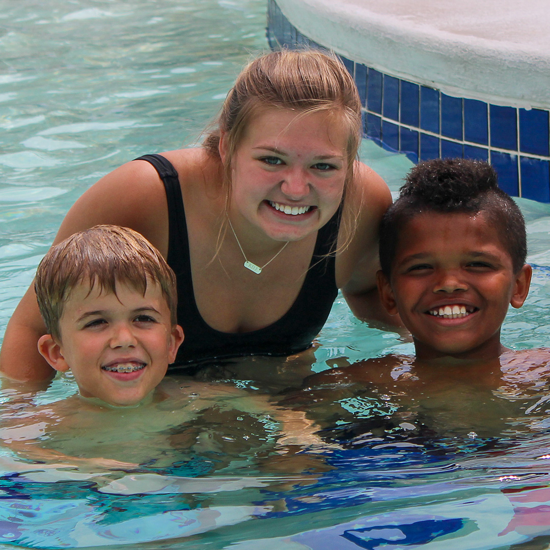 Boys with counselor in swimming pool