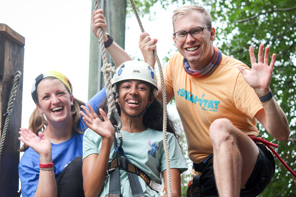 Counselor with camper at zipline