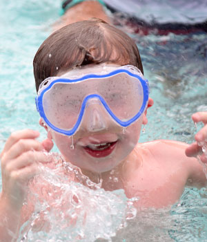 Camper with swim goggles in pool