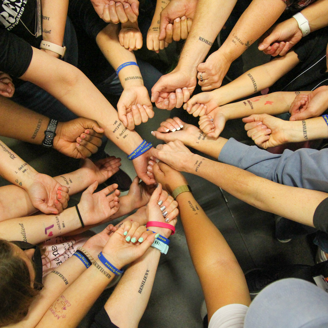 Families show the tattoos on their arms during the 2022 Fabry family weekend.