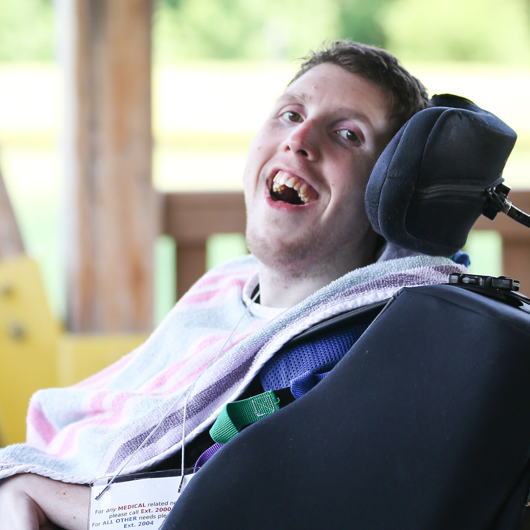 Camper in wheelchair smiling at fishing dock
