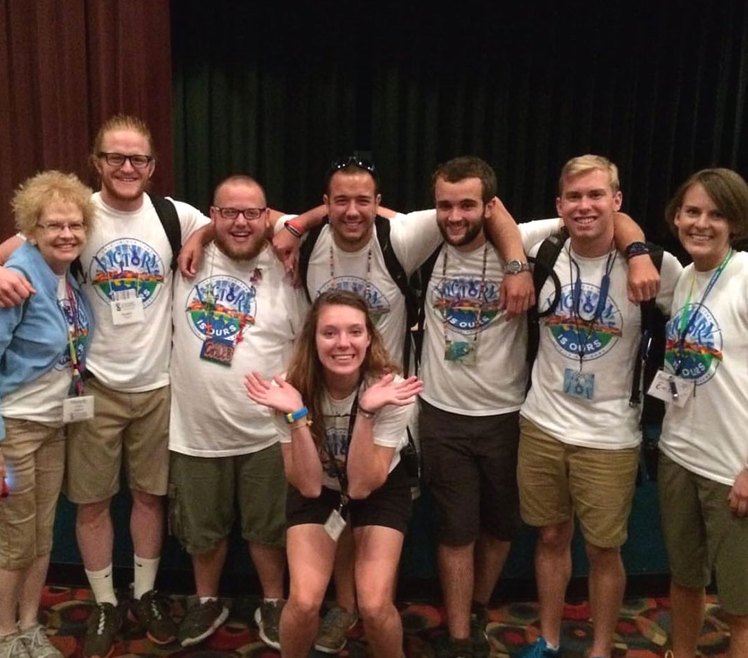Chris posing for a photo with summer staff in 2015