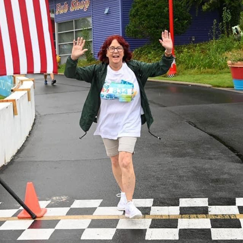 Lara Lockwood celebrates as she crosses the finish line at Run to Victory.