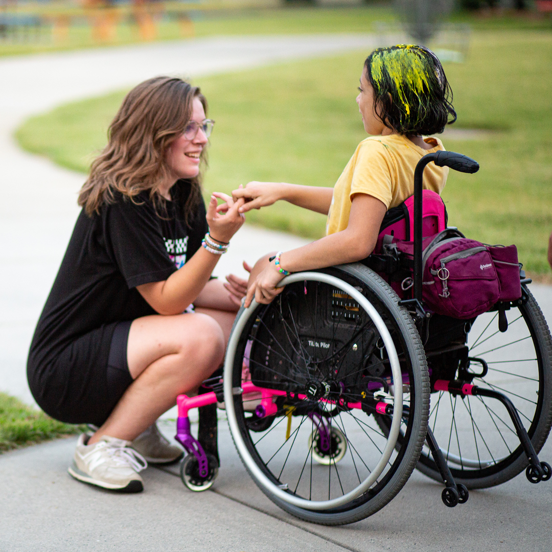 Bailey talking to a camper in a wheelchair.