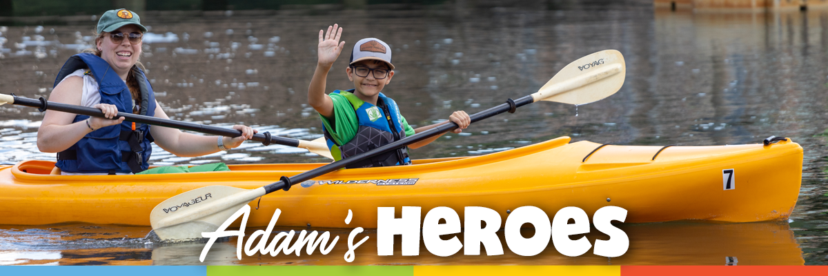 Adult and child kayaking together at Victory Junction, with the title “Adam’s Heroes.”
