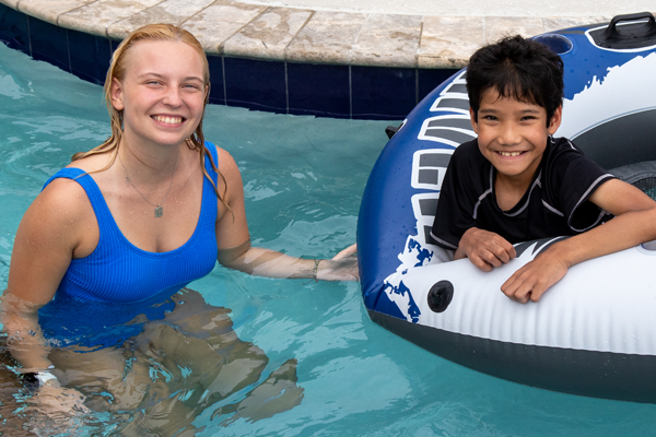 amper and counselor smiling together in a swimming pool.