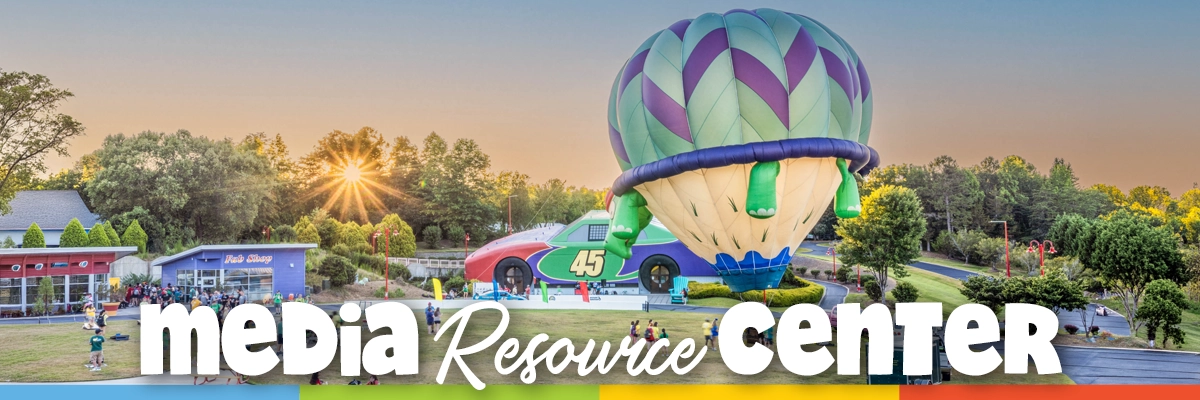 Sunset view of the Victory Junction campus with the Adam's Race Shop building and a large hot air balloon on the lawn.