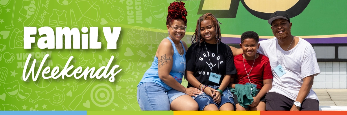 Family Weekends Banner 1200x400 A camper smiles with their family while attending a Victory Junction Family Weekend.