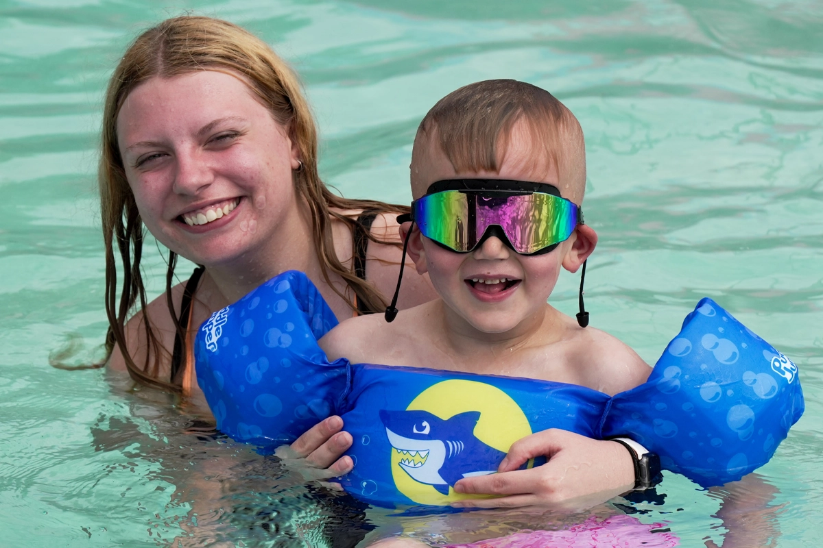 Camper enjoying a swimming activity with a counselor at Victory Junction.