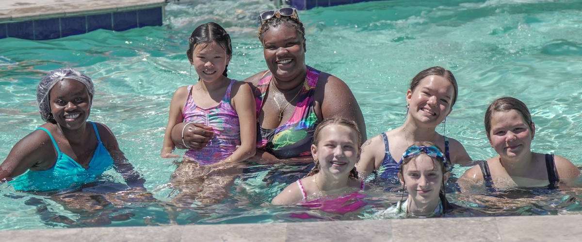 Campers and staff enjoy time together in the Victory Junction water park, smiling and relaxing in the pool.