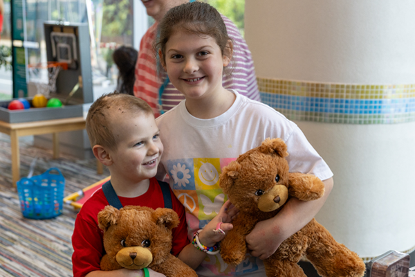 Victory Junction OUTREACH Image 3 Two smiling children hold teddy bears while participating in a Victory Junction OUTREACH activity.